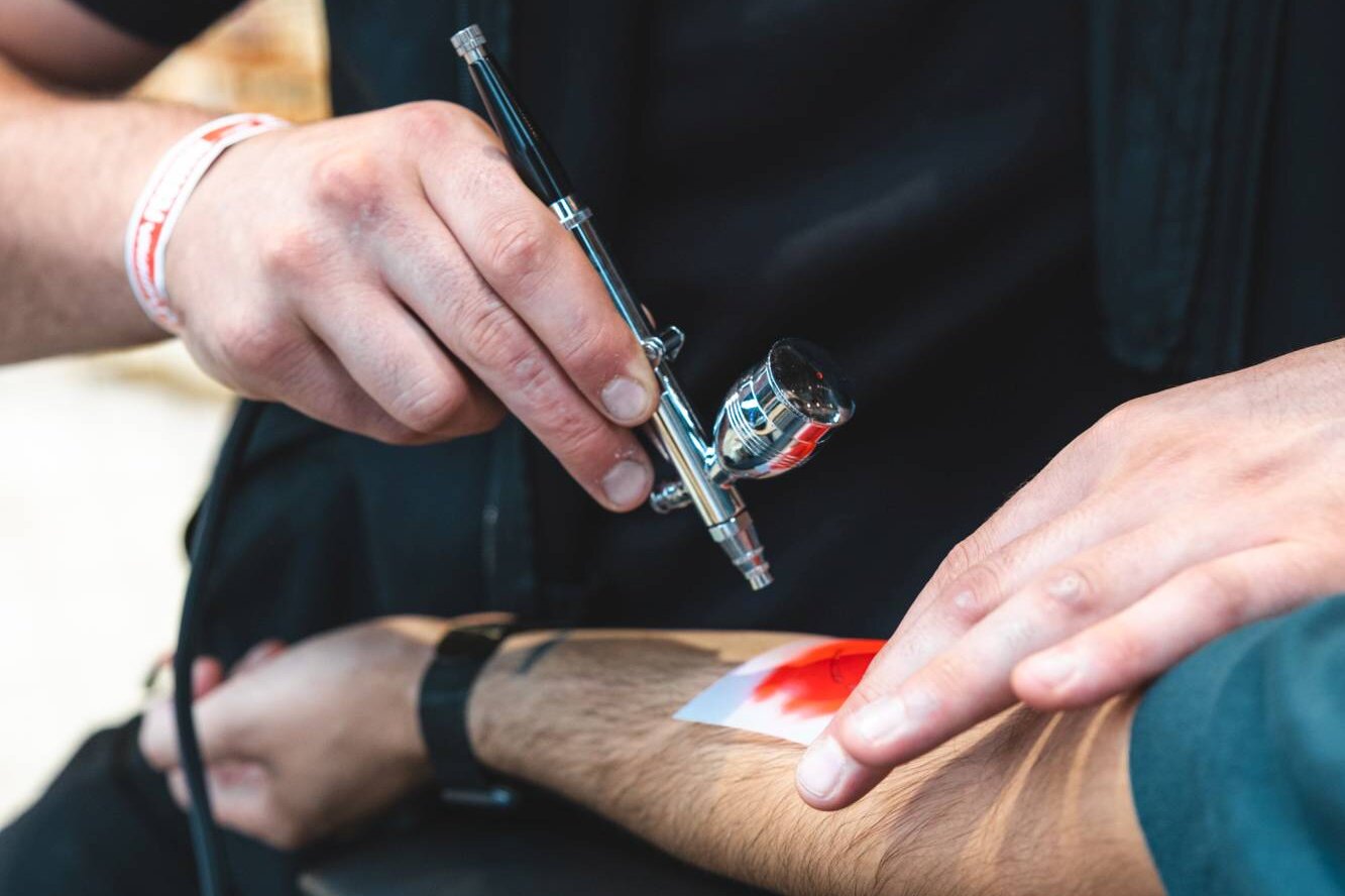 Airbrush Artist sprüht ein Tattoo beim Sommerfest der Sparkasse im Rheinriff Düsseldorf